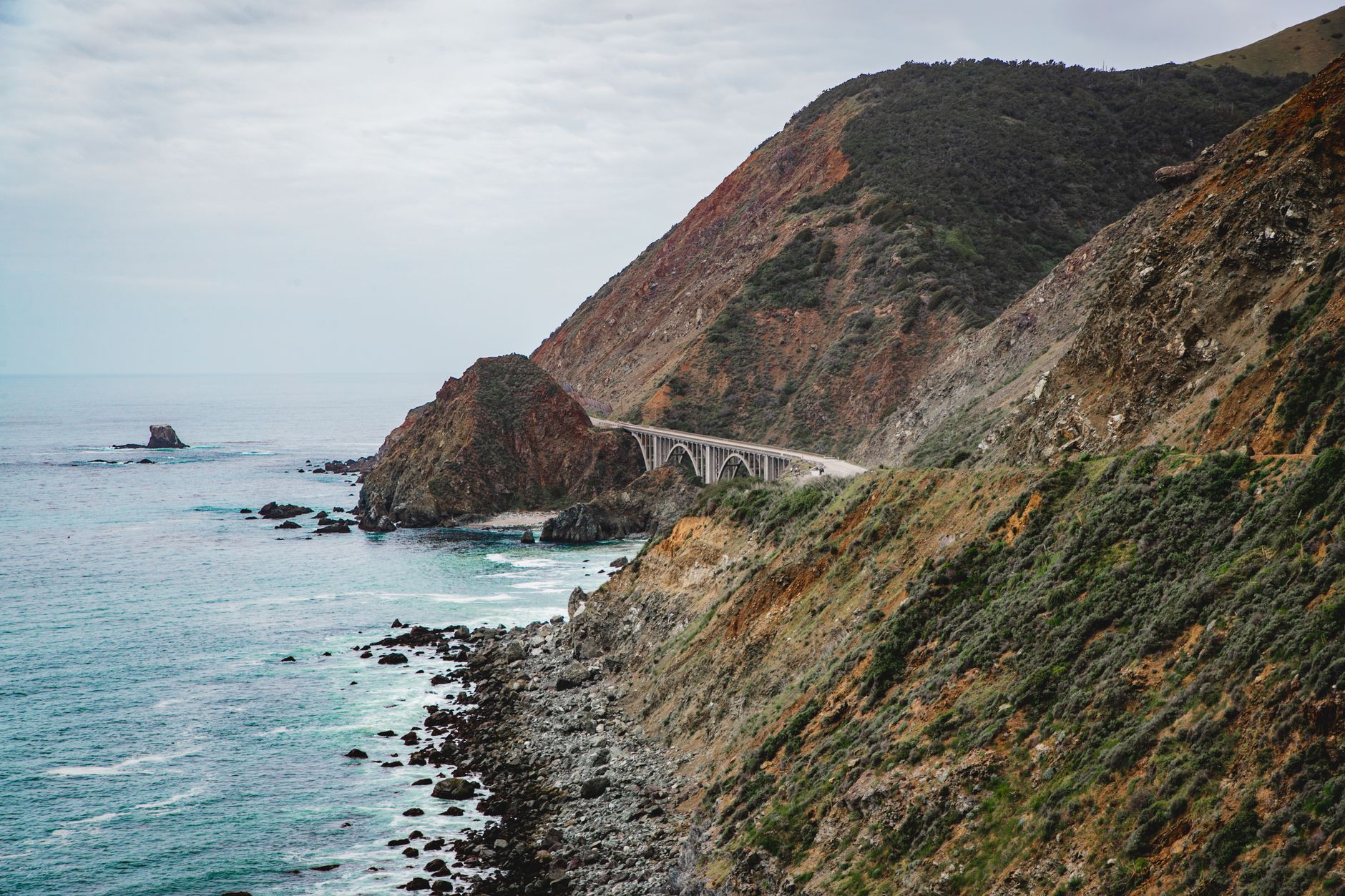 Solo traveler driving along a coastal cliff road